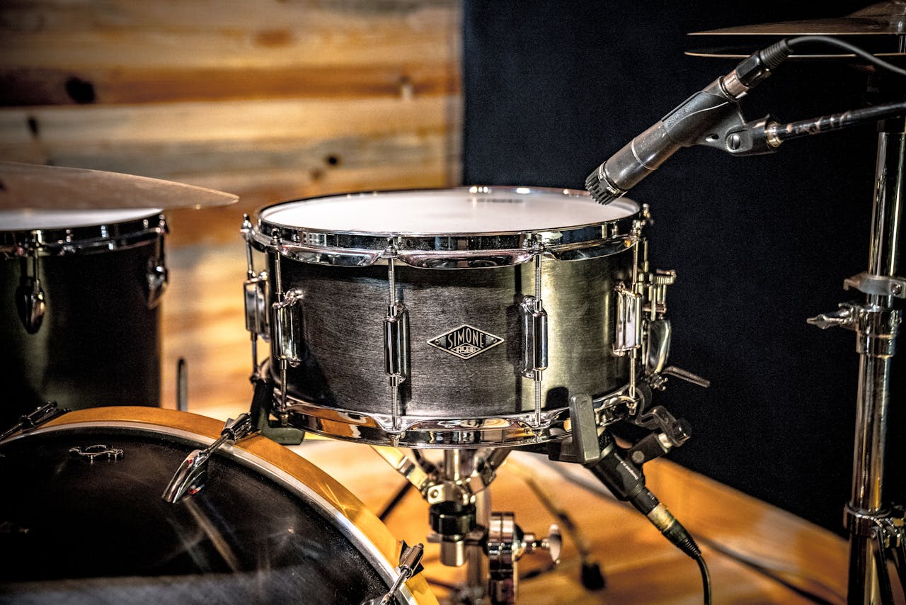 Detailed view of a drum set with microphone setup in a studio environment.