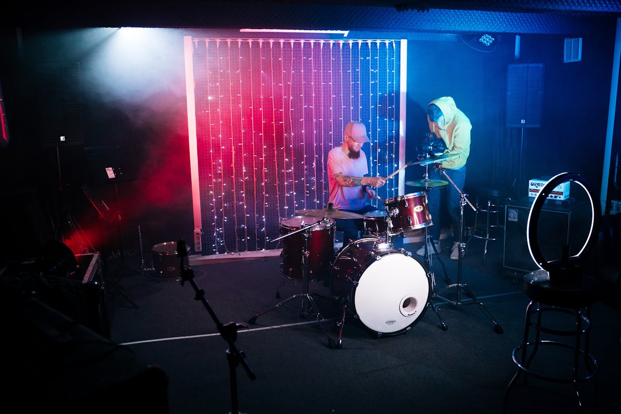 Energetic drummer performing with colorful lights on stage, filmed for a music video.