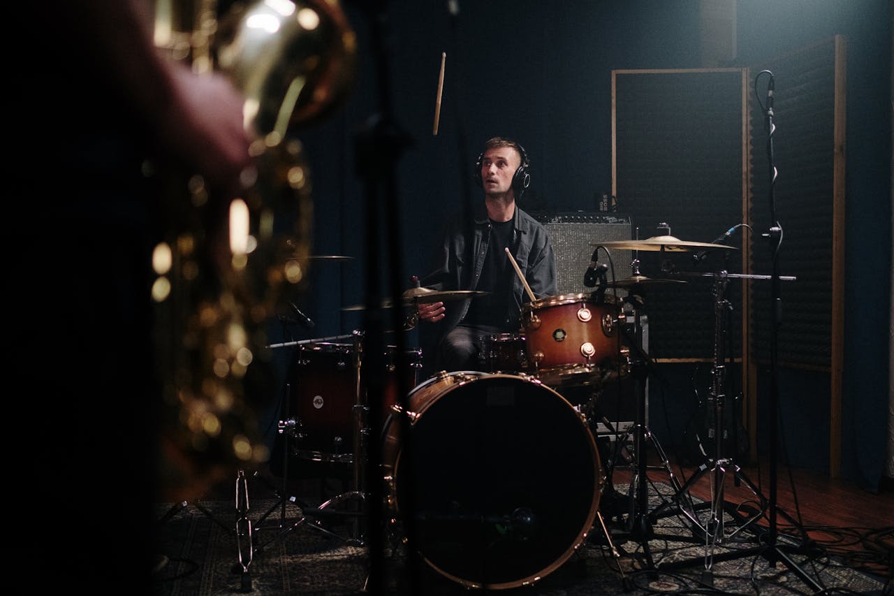 Musician playing drums in a sound studio, captured during a recording session.